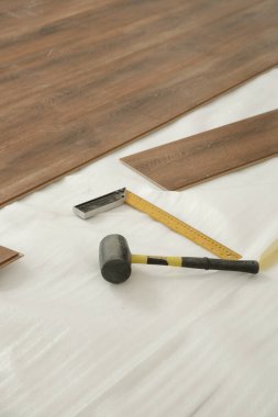 Lastik çekiç, cetvel, bant ölçer, testere ve plastik zemin montajı için diğer aletler. Ev geliştirme, yeni zemin kurulumu.