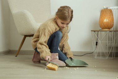 7 yaşında küçük süpürge ve faraşla apartman dairesini temizleyen bir kız. Bir çocuğun rutinindeki angarya işleri de dahil olmak üzere daha fazla özsaygı, daha fazla sorumluluk ve hüsranla daha iyi başa çıkabilirsiniz.