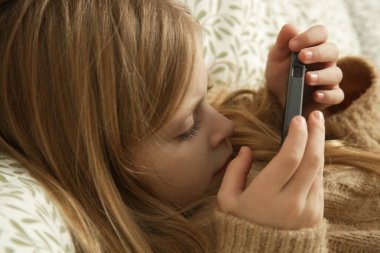 Evde akıllı telefon kullanan tatlı küçük kız.