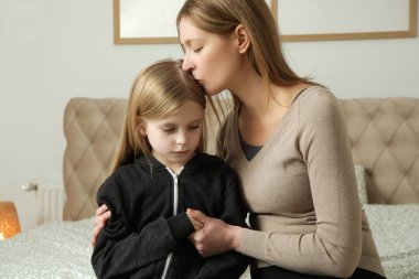 Sevgi dolu anne üzgün küçük kızını teselli ediyor.