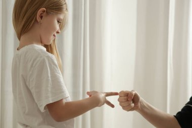 Anne ve kızı yatak odasında makas oynuyorlar kağıt taş oyunu oynuyorlar.