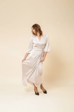 Stüdyo fotoğrafları. Lüks ipek, saten, maksimum sarılı elbise giymiş kadın modelin fotoğrafları..