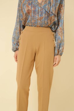 Stüdyo fotoğrafları, güzel sonbahar kıyafetleri, sonbahar mavi boho bluzu ve bej pantolon giyen genç kadın modeller.