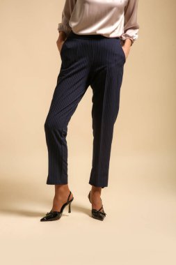 Stüdyoda çekilmiş, kadın modelin basit çizgili sigara izmaritli pantolon giydiği fotoğraflar.