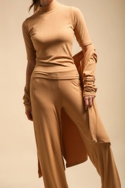 Rahat bej, rahat, şezlonglu bir takım elbise giyen bir kadın manken. Klasik ve basit moda. Stüdyo çekimi. 