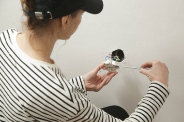 Elektrik prizi tamir ve montaj - ev geliştirme kavramları. Usta elektrikçi eve bir soket takıyor. DIY ev projesi.