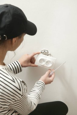 Elektrik prizi tamir ve montaj - ev geliştirme kavramları. Usta elektrikçi eve bir soket takıyor. DIY ev projesi.