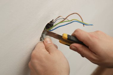 Elektrik prizi tamir ve montaj - ev geliştirme kavramları. Usta elektrikçi eve bir soket takıyor. DIY ev projesi.