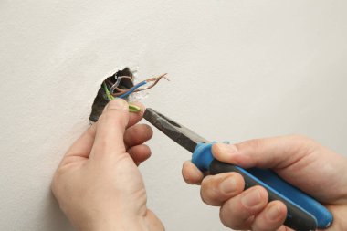 Elektrik prizi tamir ve montaj - ev geliştirme kavramları. Usta elektrikçi eve bir soket takıyor. DIY ev projesi.