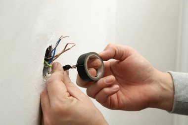 Elektrik prizi tamir ve montaj - ev geliştirme kavramları. Usta elektrikçi eve bir soket takıyor. DIY ev projesi.