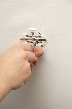 Elektrik prizi tamir ve montaj - ev geliştirme kavramları. Usta elektrikçi eve bir soket takıyor. DIY ev projesi.