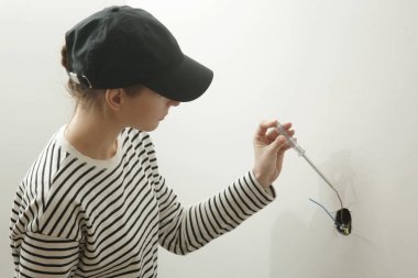 Elektrik prizi tamir ve montaj - ev geliştirme kavramları. Usta elektrikçi eve bir soket takıyor. DIY ev projesi.