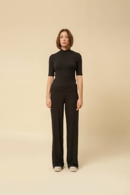 Rahat, siyah, rahat, şezlong bir takım elbise giyen bir manken. Klasik ve basit moda. Stüdyo çekimi.