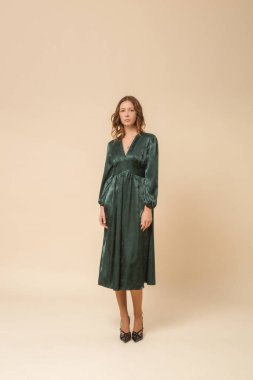 Stüdyo fotoğrafları. Güzel, ipek, saten bir elbise giymiş genç bir kadın model..