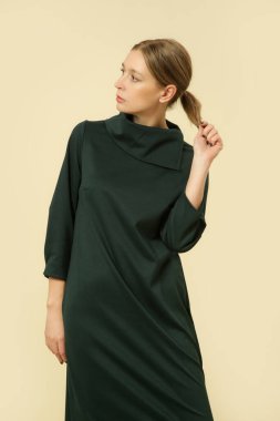 Stüdyo fotoğrafları, yeşil Midi elbisesi giyen genç bir kadın manken.