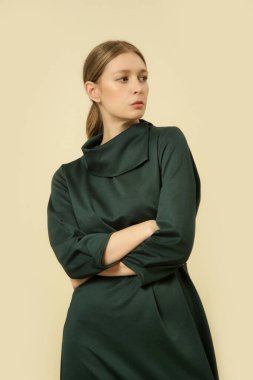 Stüdyo fotoğrafları, yeşil Midi elbisesi giyen genç bir kadın manken.