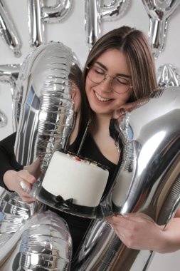 Doğum günü stüdyosu fotoshoot. Beyaz arka planda helyum balonları olan beyaz kız fotoğraf çekimi. 