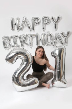 Doğum günü stüdyosu fotoshoot. Beyaz arka planda helyum balonları olan beyaz kız fotoğraf çekimi. 