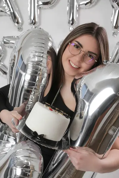 Doğum günü stüdyosu fotoshoot. Beyaz arka planda helyum balonları olan beyaz kız fotoğraf çekimi. 