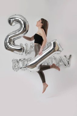 Doğum günü stüdyosu fotoshoot. Beyaz arka planda helyum balonları olan beyaz kız fotoğraf çekimi. 