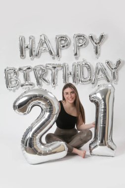 Doğum günü stüdyosu fotoshoot. Beyaz arka planda helyum balonları olan beyaz kız fotoğraf çekimi. 