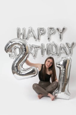 Doğum günü stüdyosu fotoshoot. Beyaz arka planda helyum balonları olan beyaz kız fotoğraf çekimi. 