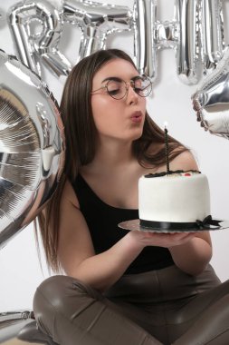 Doğum günü stüdyosu fotoshoot. Beyaz arka planda helyum balonları olan beyaz kız fotoğraf çekimi. 