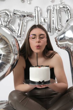 Doğum günü stüdyosu fotoshoot. Beyaz arka planda helyum balonları olan beyaz kız fotoğraf çekimi. 