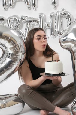 Doğum günü stüdyosu fotoshoot. Beyaz arka planda helyum balonları olan beyaz kız fotoğraf çekimi. 