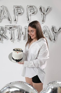 Doğum günü stüdyosu fotoshoot. Beyaz arka planda helyum balonları olan beyaz kız fotoğraf çekimi. 