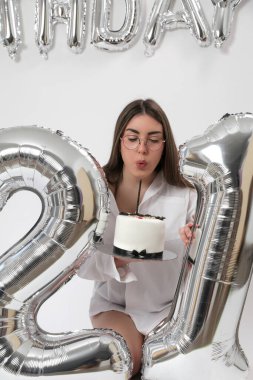 Doğum günü stüdyosu fotoshoot. Beyaz arka planda helyum balonları olan beyaz kız fotoğraf çekimi. 