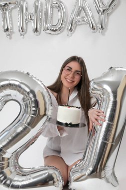 Doğum günü stüdyosu fotoshoot. Beyaz arka planda helyum balonları olan beyaz kız fotoğraf çekimi. 