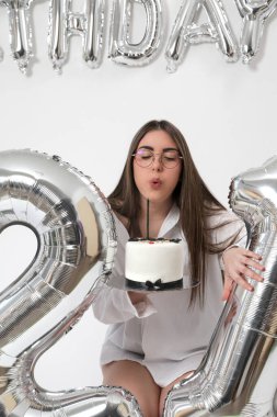 Doğum günü stüdyosu fotoshoot. Beyaz arka planda helyum balonları olan beyaz kız fotoğraf çekimi. 