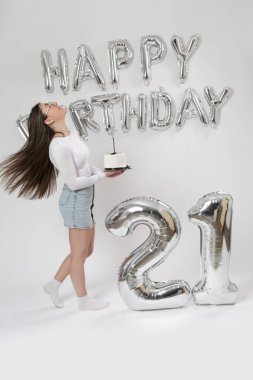 Doğum günü stüdyosu fotoshoot. Beyaz arka planda helyum balonları olan beyaz kız fotoğraf çekimi. 