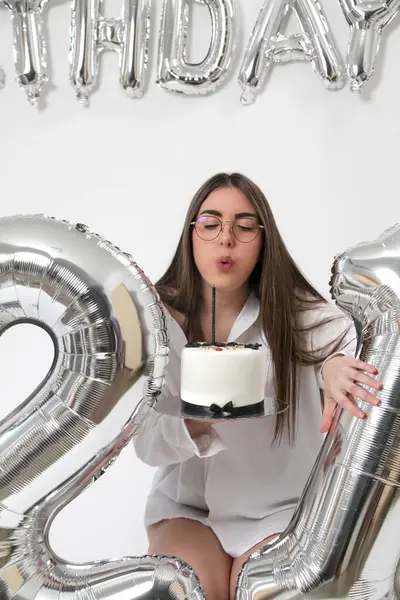 Doğum günü stüdyosu fotoshoot. Beyaz arka planda helyum balonları olan beyaz kız fotoğraf çekimi. 