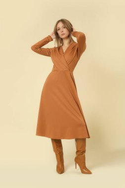 Stüdyo fotoğrafları, bej renkli V yaka Midi elbise giymiş kadın model, sonbahar kış moda koleksiyonu..