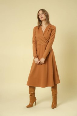 Stüdyo fotoğrafları, bej renkli V yaka Midi elbise giymiş kadın model, sonbahar kış moda koleksiyonu..