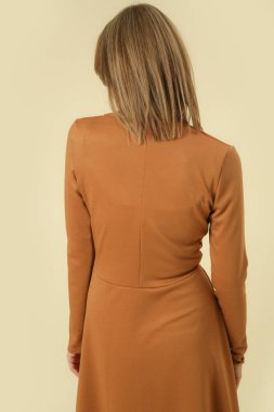 Stüdyo fotoğrafları, bej renkli V yaka Midi elbise giymiş kadın model, sonbahar kış moda koleksiyonu..