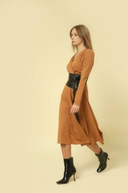 Stüdyo fotoğrafları, bej renkli V yaka Midi elbise giymiş kadın model, sonbahar kış moda koleksiyonu..