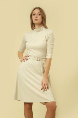 Stüdyo fotoğrafları. Krem rengi Midi elbiseli kadın model. Sonbahar kış moda koleksiyonu..
