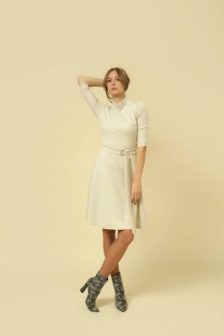 Stüdyo fotoğrafları. Krem rengi Midi elbiseli kadın model. Sonbahar kış moda koleksiyonu..