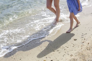 Kumsalda anne ve çocuğun çıplak ayakları..