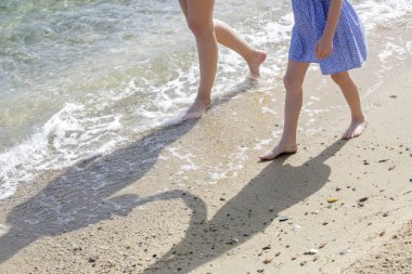 Kumsalda anne ve çocuğun çıplak ayakları..