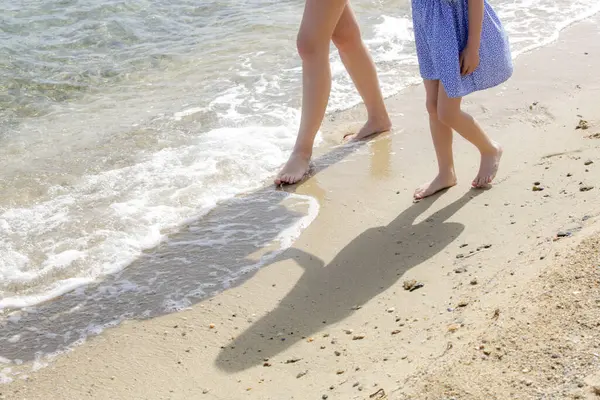 Kumsalda anne ve çocuğun çıplak ayakları..