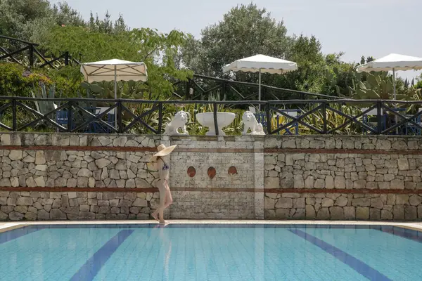 Genç bir kadın tatil köyünün havuzunda eğleniyor. Yaz tatili kavramı