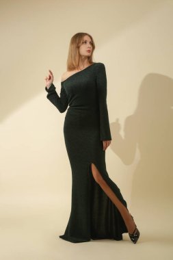 Stüdyo fotoğrafları, yırtık ve uzun kollu şık Maxi asimetrik elbise giyen kadın modeller.