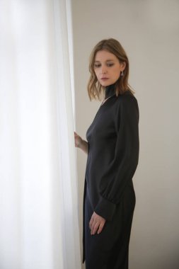 Siyah maksimum ipek giyen bir kadın model. Bir omuz asimetrik elbise.