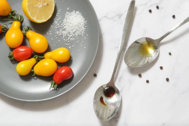 Yaz salatası malzemeleri - Taze toplanmış kiraz domatesleri, bir kaşık sirke ve zeytinyağı, tuz ve biber