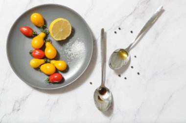 Yaz salatası malzemeleri - Taze toplanmış kiraz domatesleri, bir kaşık sirke ve zeytinyağı, tuz ve biber