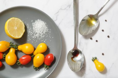 Yaz salatası malzemeleri - Taze toplanmış kiraz domatesleri, bir kaşık sirke ve zeytinyağı, tuz ve biber